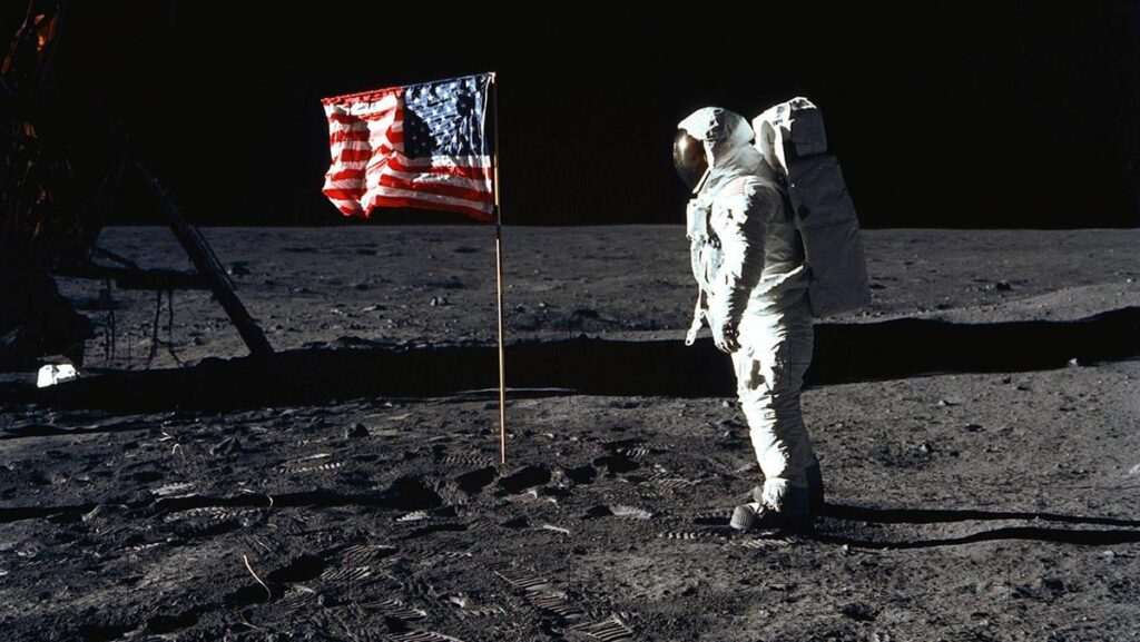 ay yüzeyinde astronot ve Ameikan bayrağı